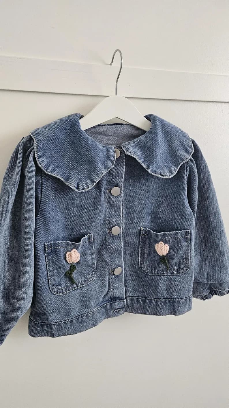 Denim kinderjas zijaanzicht met geborduurde bloemen